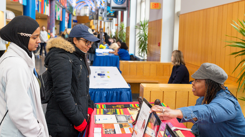 at International Student Orientation, two students visit a table in Trabant where a staff member provides information